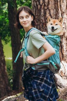 犬を背負い笑顔を見せる女性 女性,犬,柴犬の写真素材