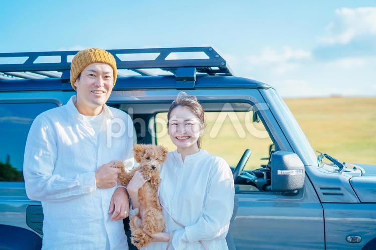 車でお出かけする犬と男女（車の前） 車,犬,旅行の写真素材