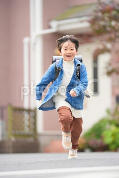 ダッシュで登校する男の子（縦）2 男の子,笑顔,にっこりの写真素材