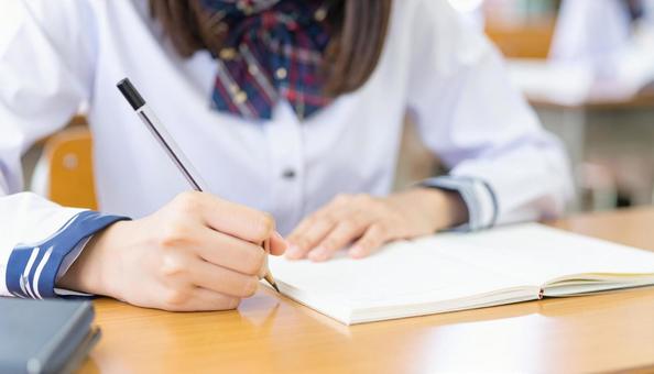 ノートに記入する日本人中学生の女の子の手 ノートに記入する日本人中学生の女の子の手の写真