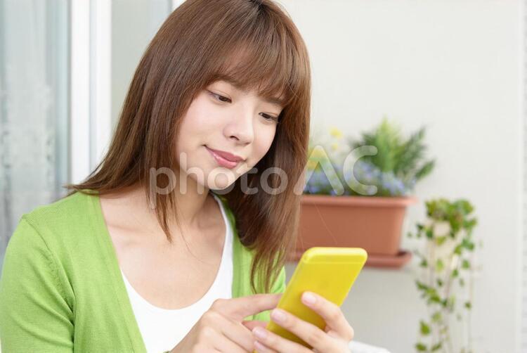 スマートフォンを持つ笑顔の女性 女性,スマートフォン,女の写真素材