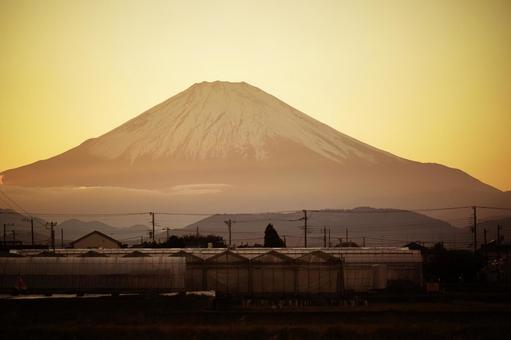 淡い夕焼け空にそびえる富士山の写真