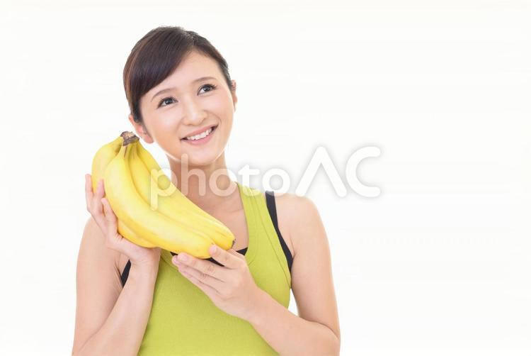 バナナを持つタンクトップを着た女性 女性,食べ物,果物の写真素材