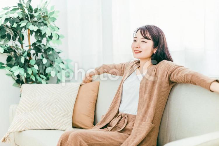 ソファで深呼吸する日本人女性（寝起き） ソファ,ストレッチ,仮眠の写真素材