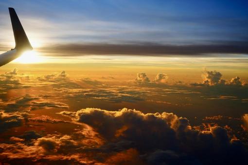 飛行機の窓から眺める夕焼け空 飛行機の窓から眺める夕焼け空の写真
