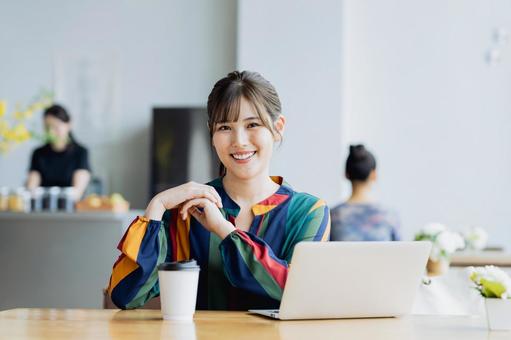 カフェで仕事をするフリーランスの女性 カフェで仕事をするフリーランスの女性の写真