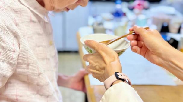台所で高齢女性の食事介助する女性 台所で高齢女性の食事介助する女性 食事介助,高齢者,高齢女性の写真素材