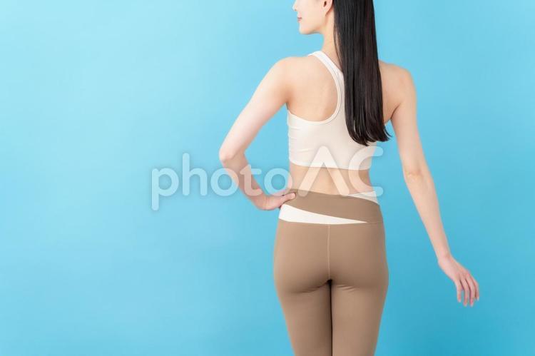 青バックのフィットネスをする若い女性 フィットネス,ヨガ,運動の写真素材