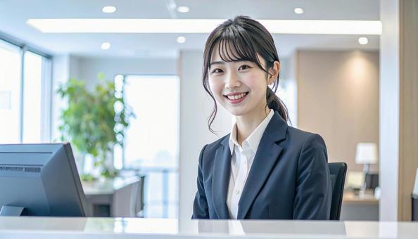 笑顔で対応する女性の受付嬢 笑顔で対応する女性の受付嬢の写真