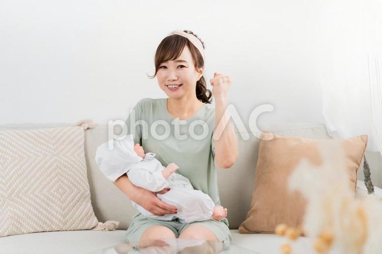 赤ちゃんを抱っこしてガッツポーズする女性 出産,赤ちゃん,ママの写真素材