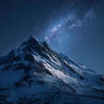 満天の星空の下、輝く雪をかぶった山々 満天の星空の下、輝く雪をかぶった山々の写真
