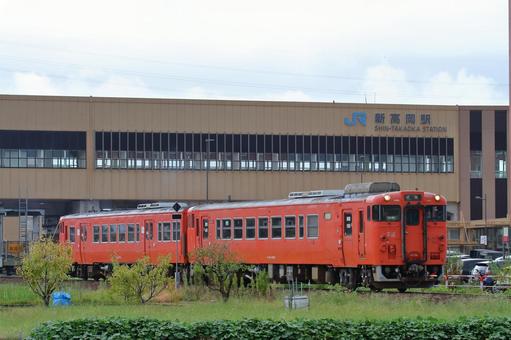 新高岡駅を後にするJR城端線の車両の写真