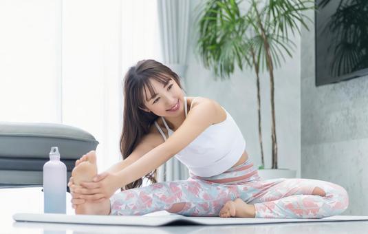自宅のリビングでストレッチをする女性 自宅のリビングでストレッチをする女性 女性,ストレッチ,柔軟の写真素材