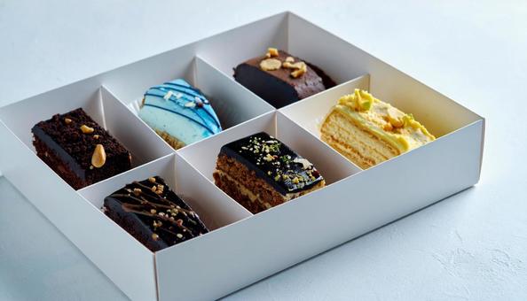 持ち帰りの箱に入ったケーキの詰め合わせ 持ち帰りの箱に入ったケーキの詰め合わせの写真