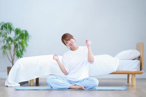 ダンベルを持ち微笑むカメラ目線の女性 女性,ダンベル,持つの写真素材