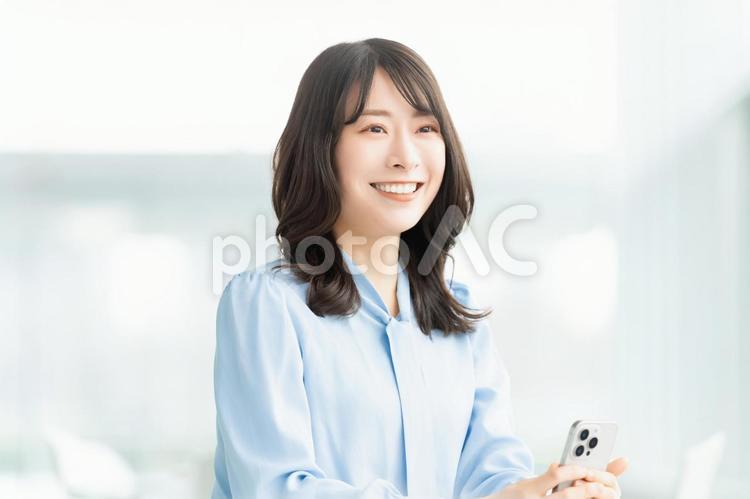 スマホを持つ笑顔の女性・ビジネスウーマン 女性,ビジネス,笑顔の写真素材