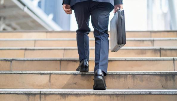 階段を登るビジネスマンの後ろ姿 階段を登るビジネスマンの後ろ姿の写真