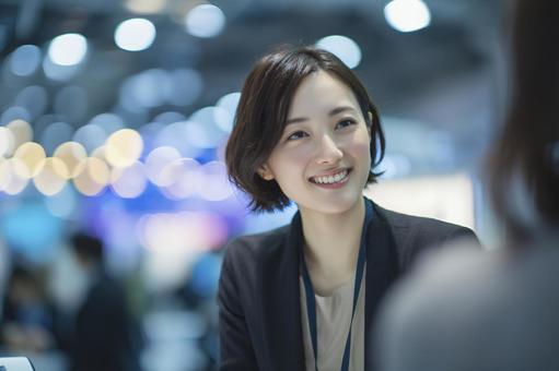 笑顔で来場者と話すイベントスタッフの写真