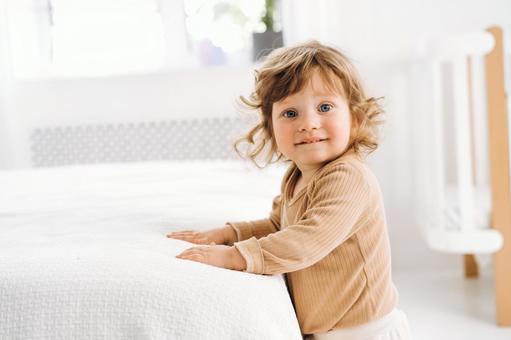 布団に手を付き嬉しそうなカメラ目線の子 布団に手を付き嬉しそうなカメラ目線の子の写真