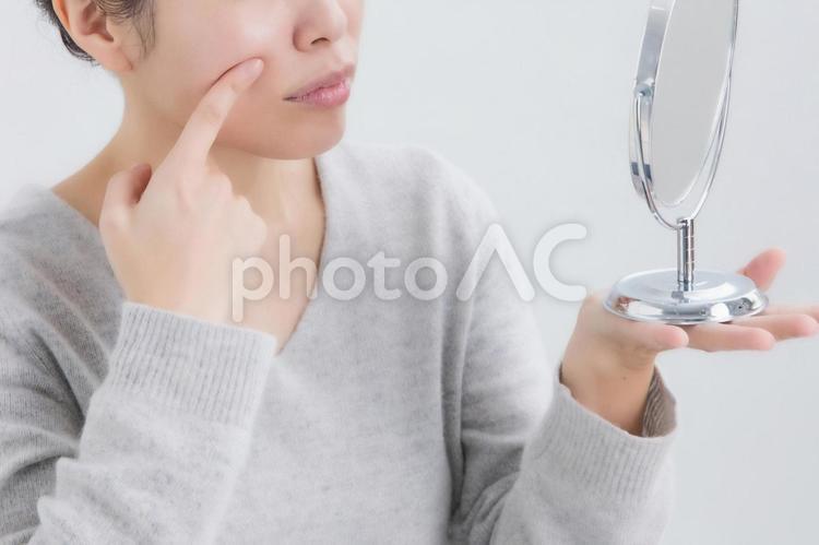 ほうせい線を触る女性（困る） ほうれい線,鼻,シワの写真素材