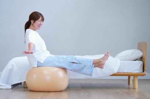 両手両足を伸ばしバランスボールに座る女性 女性,バランスボール,座るの写真素材