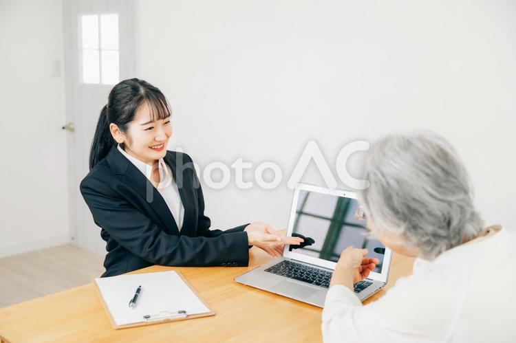 打ち合わせするスーツ姿の女性と高齢者女性 相談,終活,遺言書の写真素材