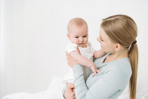 不安げな顔で抱っこされる赤ちゃん 不安げな顔で抱っこされる赤ちゃん 女性,赤ちゃん,かわいいの写真素材