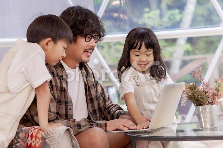 家族旅行中にリモートワーク グランピング,女性,男性の写真素材