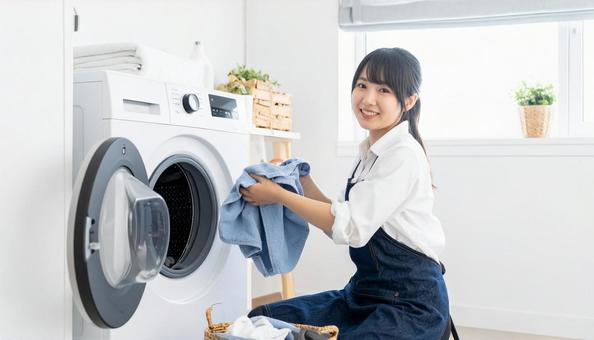 洗濯機からタオルを取り出す若い日本人女性 洗濯機からタオルを取り出す若い日本人女性の写真