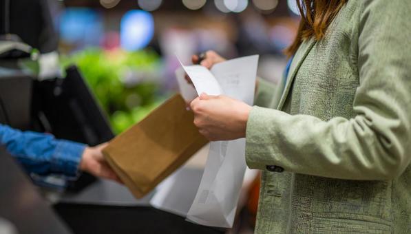 レジでレシートとおつりをもらう女性の手の写真
