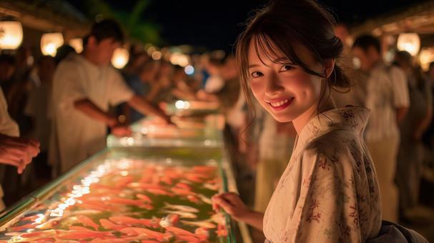 夏祭りの金魚を見て嬉しい浴衣を着た女性の写真