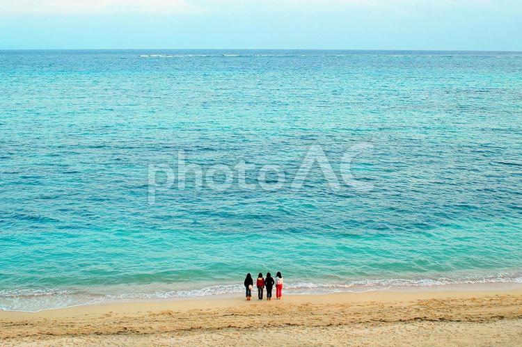 浜辺に４人の若者が立つ海の風景 海,旅人,砂浜の写真素材