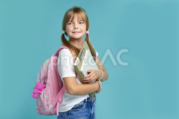バインダーとノートを抱えるロングヘアの女の子 女の子,教育,グローバルの写真素材