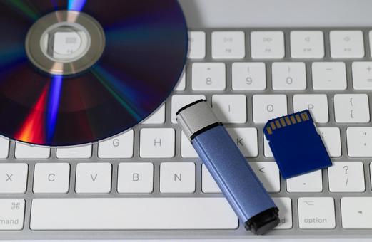 キーボード上のCD、USBメモリ、SD ディスク,cd,dvdの写真素材