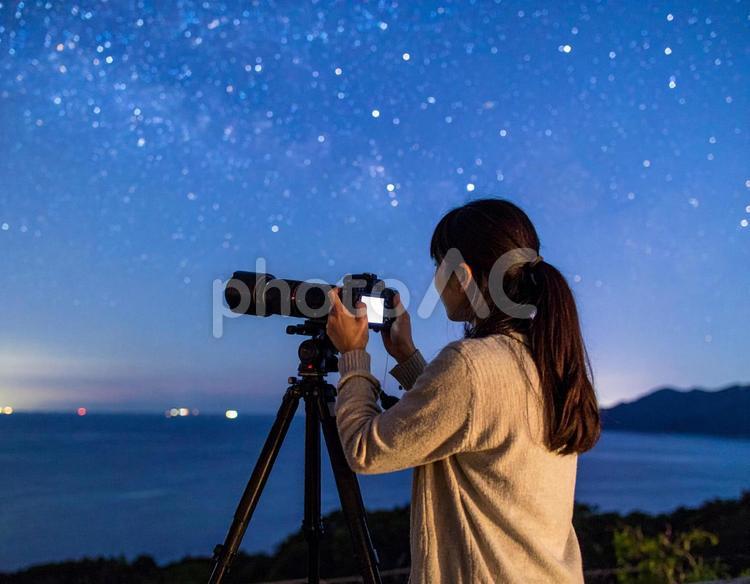 三脚を使って星空を撮影する女性 星,撮影,女性の写真素材