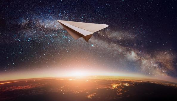 宇宙に向かって飛んでいる紙飛行機 宇宙に向かって飛んでいる紙飛行機の写真