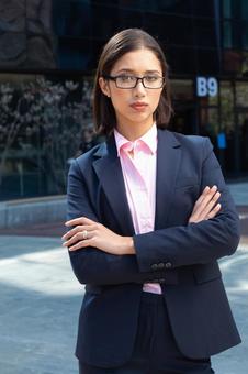 オフィスビルの外で腕組みをして立つカメラ目線のビジネスウーマン ビジネスウーマン,ビジネス,女性の写真素材