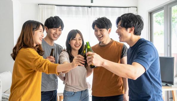 ホームパーティーで乾杯する若い日本人男女 ホームパーティーで乾杯する若い日本人男女の写真