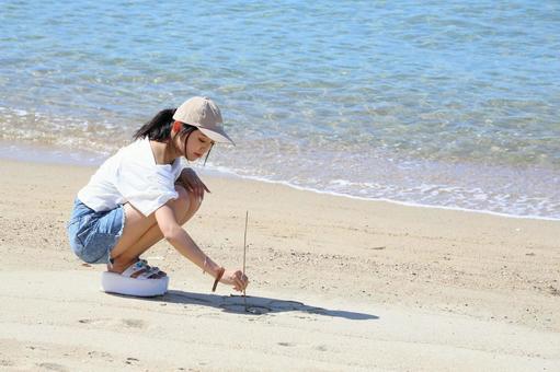砂浜に落書きをする女性 砂浜に落書きをする女性 女性,海,夏の写真素材