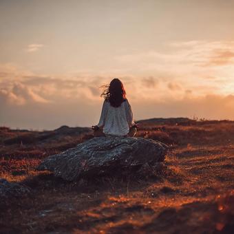 朝焼けを背景に瞑想する女性のシルエット 朝焼けを背景に瞑想する女性のシルエットの写真