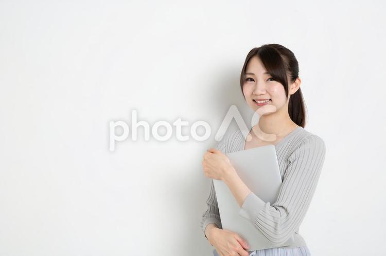 パソコンを抱えているポニーテールの女性（コピースペース） 女,女性,日本人の写真素材