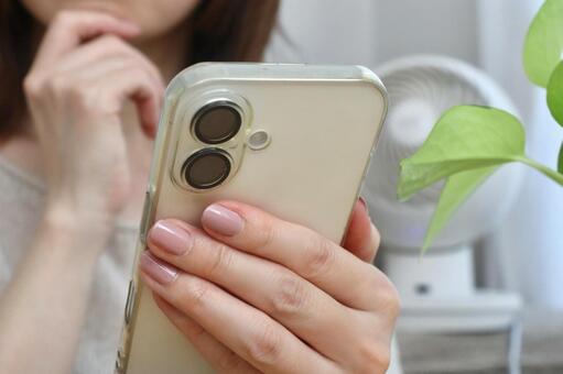スマホを見ながら考える女性 スマホ,女性,考えるの写真素材