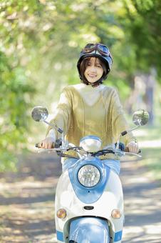 バイクに乗る若い女性 バイクに乗る若い女性 バイク,女性,スクーターの写真素材