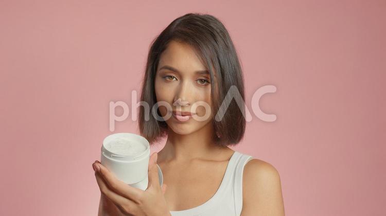 クリームの容器を持っている女性 女性,外国人,アジア人の写真素材