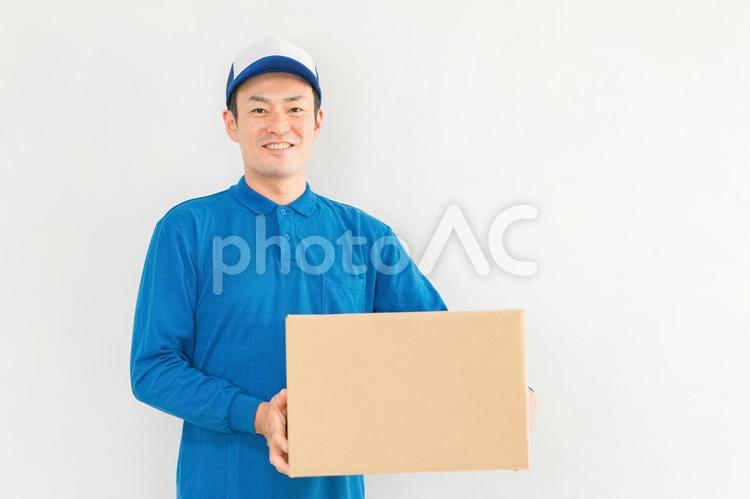 段ボールを持つ引越し業者・配達員の男性 配達,引越し,宅配の写真素材