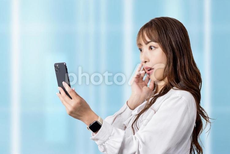 スマホの画面を見て驚くビジネスウーマン 女性,ビジネス,スマホの写真素材
