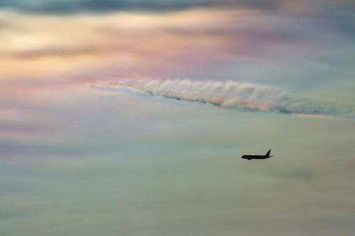 幻想的な彩雲と飛行機のシルエット 幻想的な彩雲と飛行機のシルエットの写真