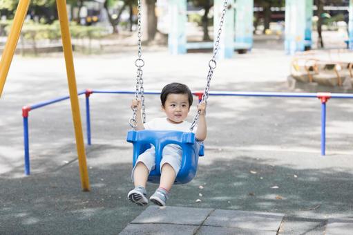 Boy playing on a swing, JPG