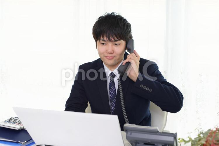受話器を持つ笑顔のビジネスマン 男性,男,パソコンの写真素材