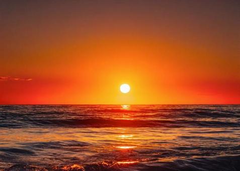 夕暮れの海に沈む太陽 夕暮れの海に沈む太陽の写真